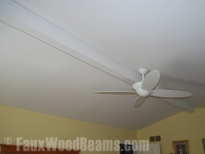 Faux Beam Installed Cathedral ceiling with a recurring crack is improved with a faux ceiling beam.