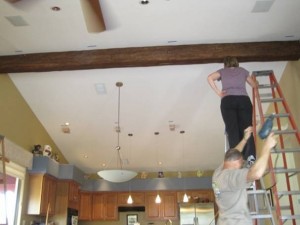 Fake wood timber beam being installed in a kitchen