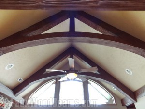 Arched Woodland beams used to built modified king trusses in a living room.