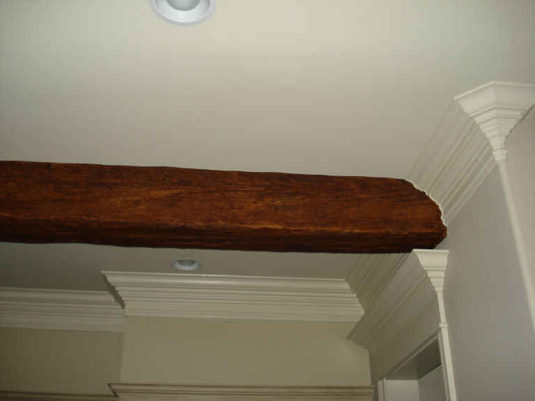 Faux timber beam scribed to blend with the crown molding in a kitchen.