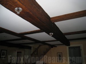 Hollow faux wood beams make a perfect way to hide sprinkler system pipes while beautifying your home.