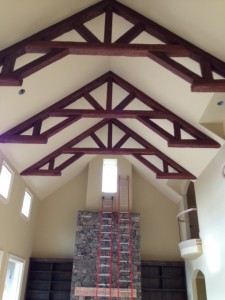 Cathedral ceiling with elaborate king post trusses made from faux Timber beams.