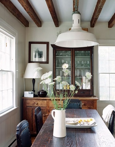 Beams frame a hanging lamp and add rustic charm to this casual dining area