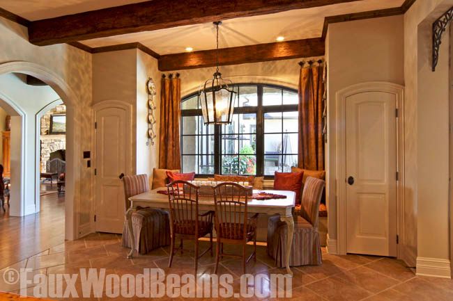 Dining room with a cozy window seat enhanced with faux beams.