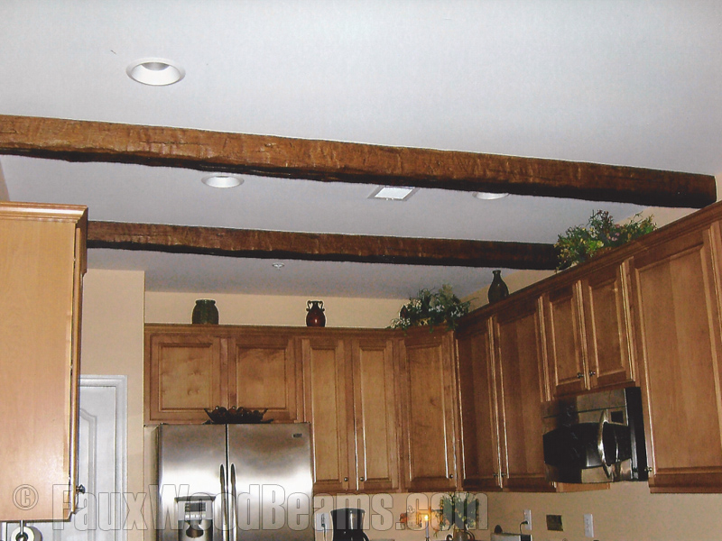 Heavily distressed timber beams installed on a kitchen ceiling.