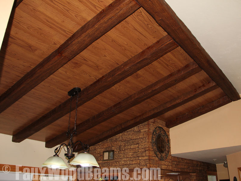 Faux exposed wood beams combine with planks to create a beautiful design in a kitchen.