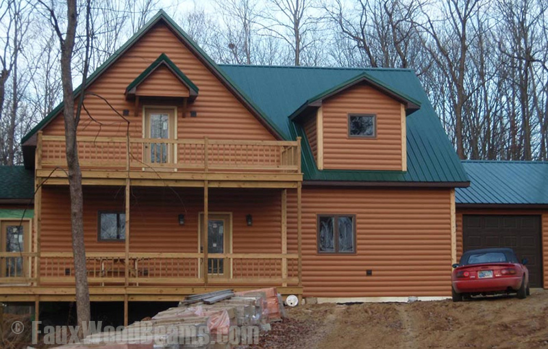 Home with log style vinyl panels installed on the exterior.