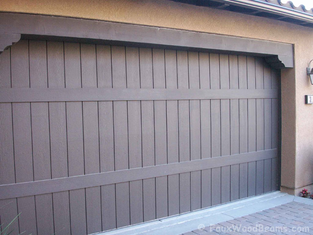Wood style door header with corbels above a garage door.