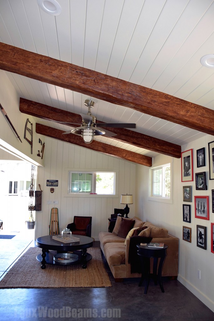 Garage converted man cave with exposed Timber beams installed on a white plank ceiling.