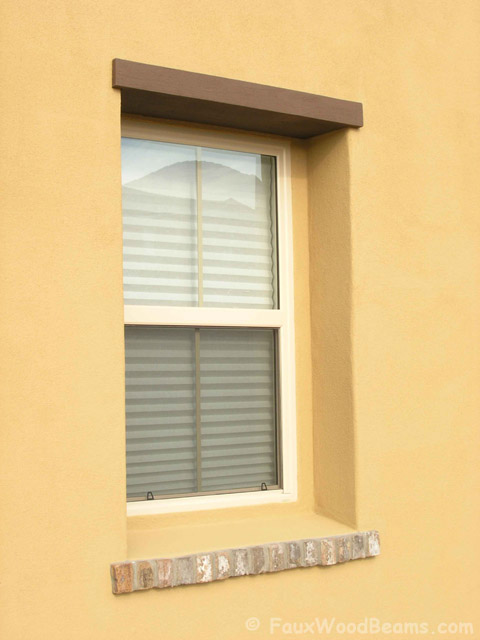Faux wood window header installed on a stucco home.