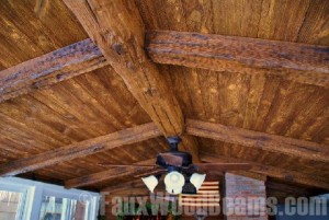 Planks combined with beams on an antique home's ceiling, consistent with the home's rustic design.