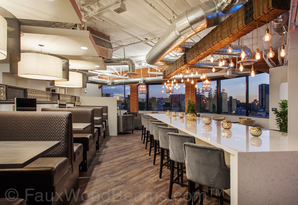 A rustic beam with dripping light bulbs beautifully accents the bar in this high-rise restaurant.