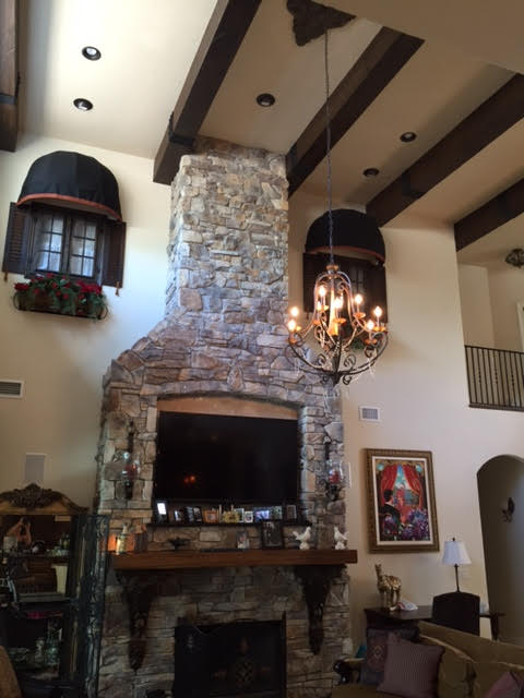 Tuscan style home with authentic stone fireplace complimented with faux hand hewn beams.