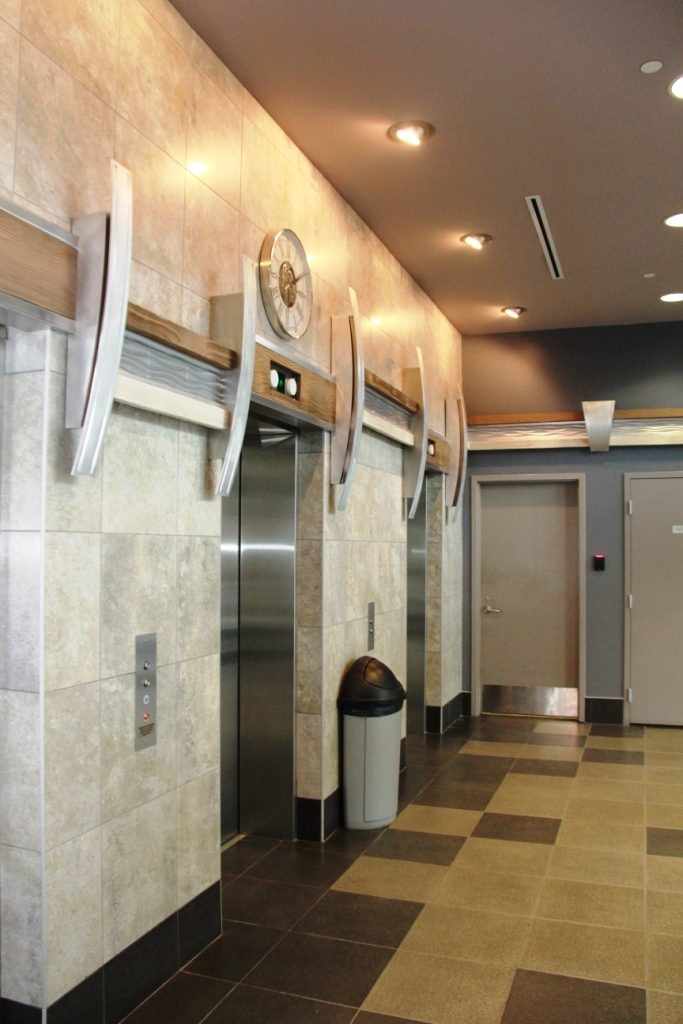 Elevator bank in the Executive Place lobby with new wood style beams installed.