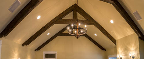 Modified king trusses in a new home's great room, made from faux beams.