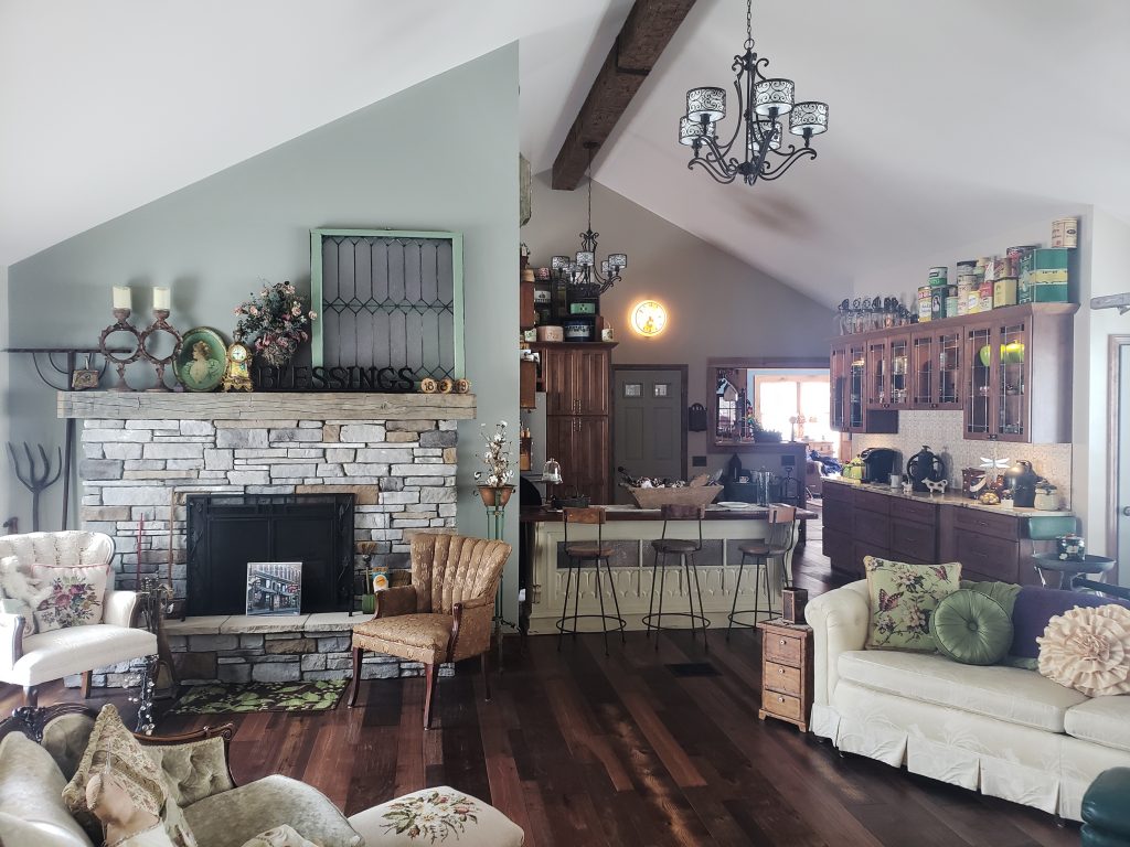 Renovated open-plan living room and kitchen, with Custom Rough Hewn beams used to wrap the ceiling's structural support.