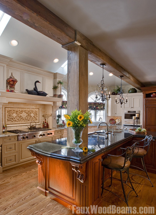 Kitchen with large beam and hanging light fixtures.