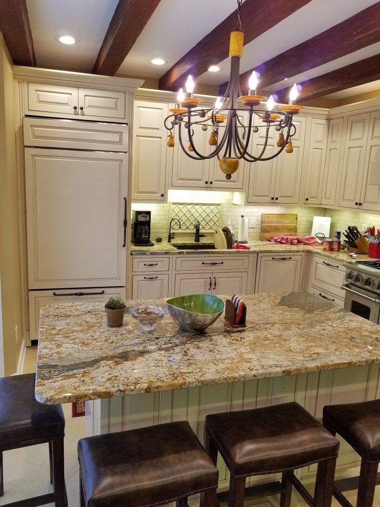 Subtle design details like the dark cabinet handles, painted island and wood style beams really raised the bar on this kitchen remodel.