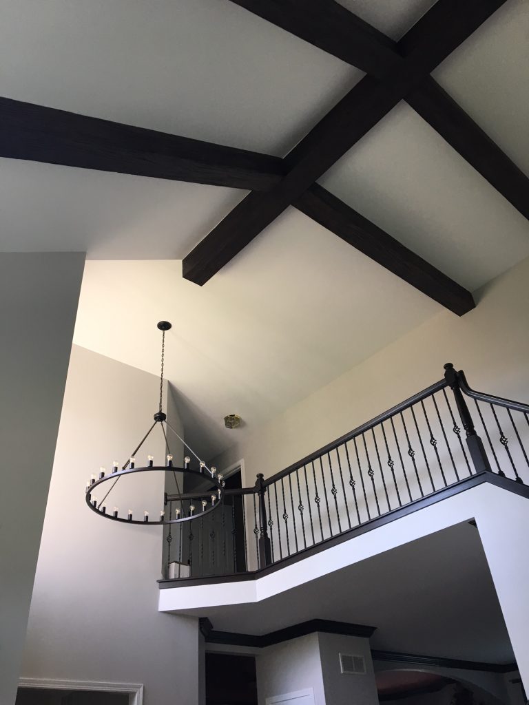 The beams look great alongside the medieval-style decor details, such as the wrought iron banisters and circle chandelier.