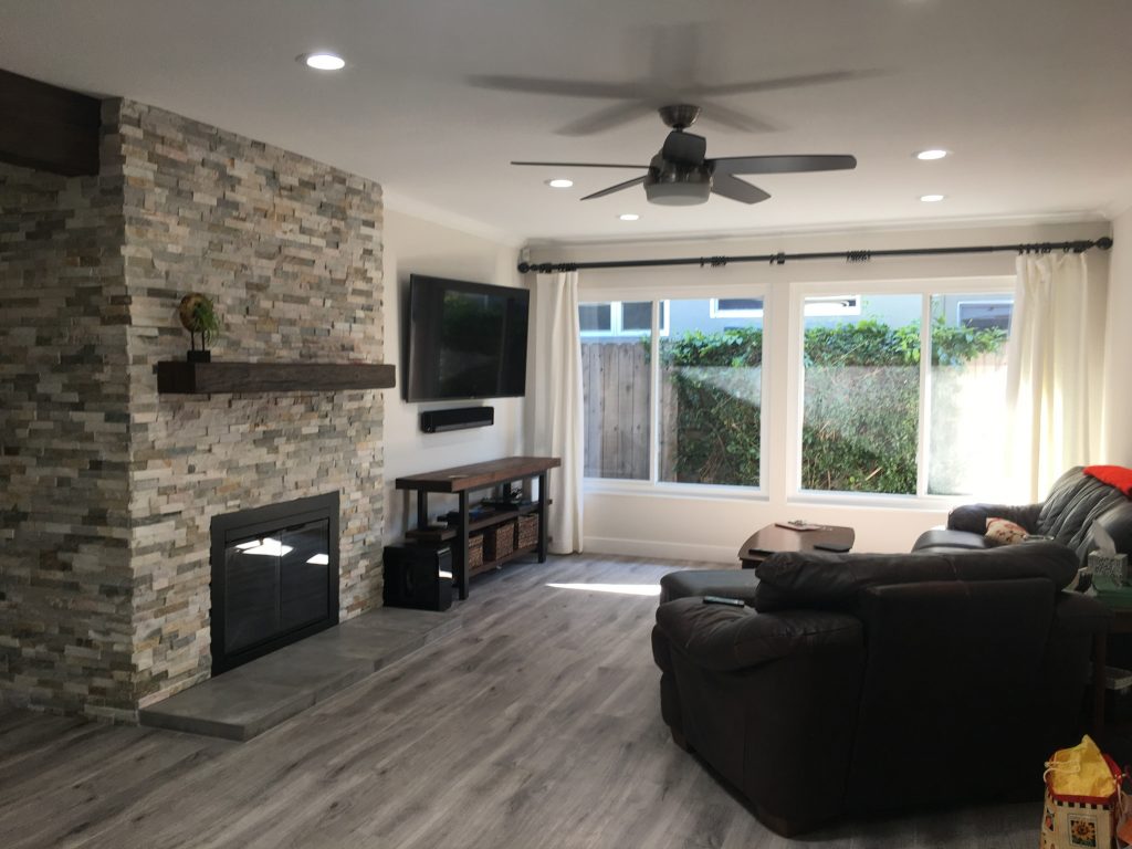 Open plan living room remodeled with new stone fireplace and Custom Timber mantel.