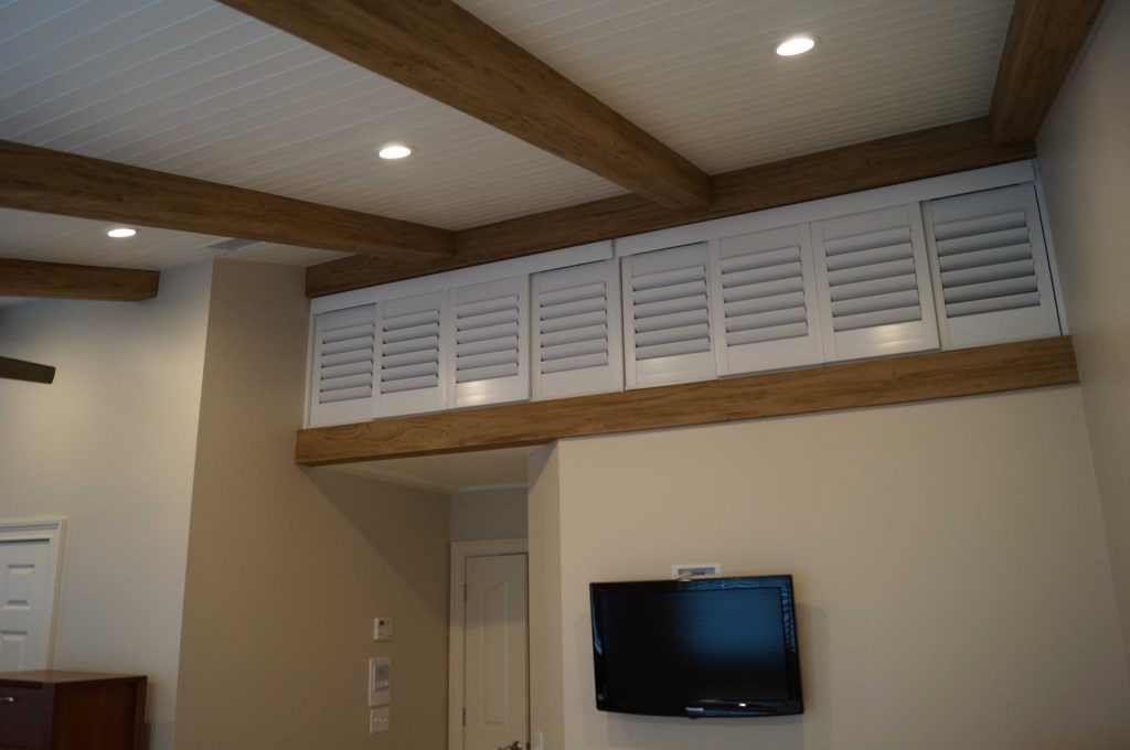 AFTER: Practical and style new storage cupboards installed near a bedroom's ceiling.