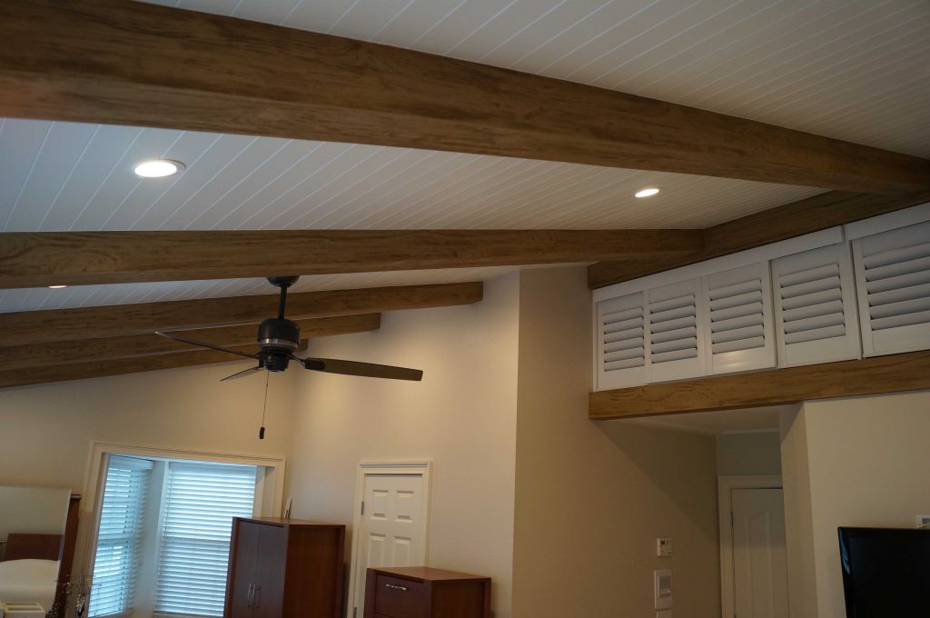 Beams installed on a bedroom ceiling that resemble real structural supports.