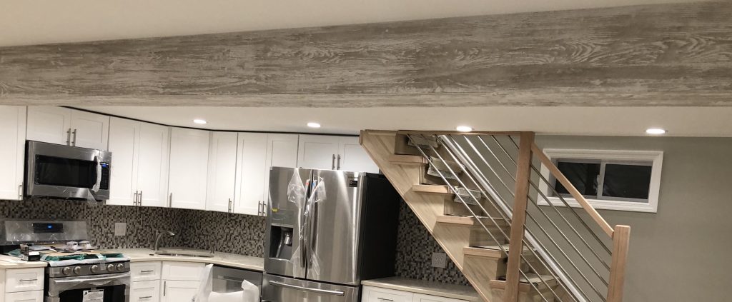 Driftwood beam closeup in finished basement with kitchen.