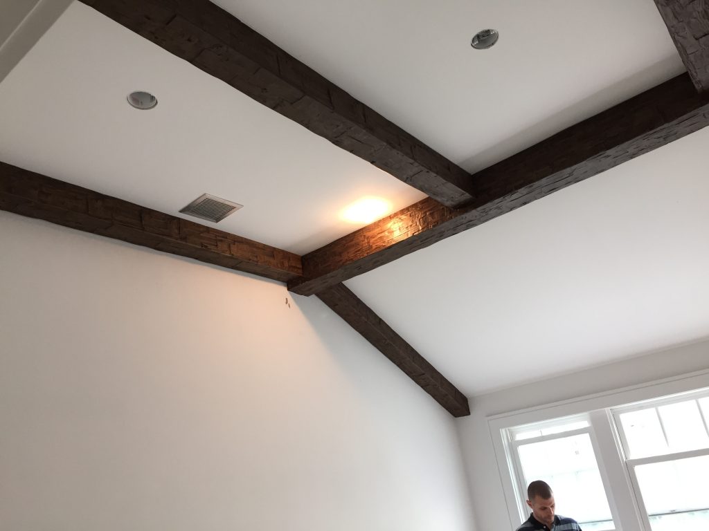 The smaller beams were carefully cut and installed, fitting flush with the wall and central beam.
