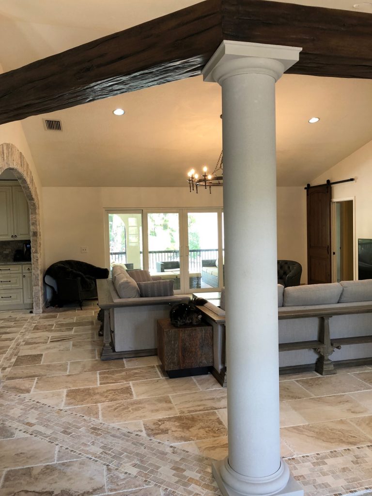 Replica stone columns support the beams, and offer another design element to separate the two spaces.