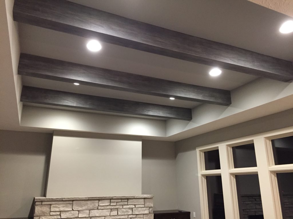 Faux Resawn beams in Gray Patina finished installed in a renovated living room's ceiling.