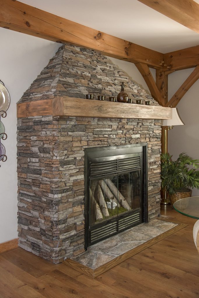 Closeup view of faux driftwood mantel stained to match the living room's beams and other wood fixtures.