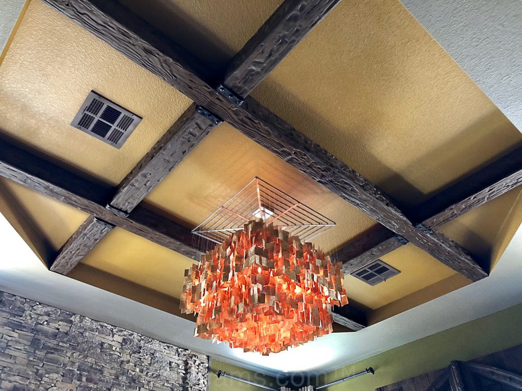 Cross beams on a bedroom's tray ceiling decorated with rubber beam straps