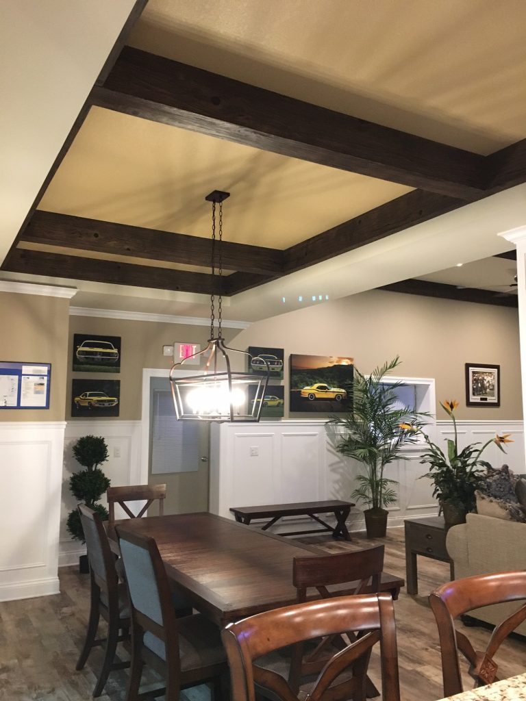 Driftwood beams installed in a recessed ceiling above the dining area.