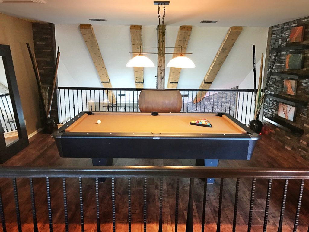 The game room mezzanine offers the best view to appreciate our Custom Hand Hewn beams.