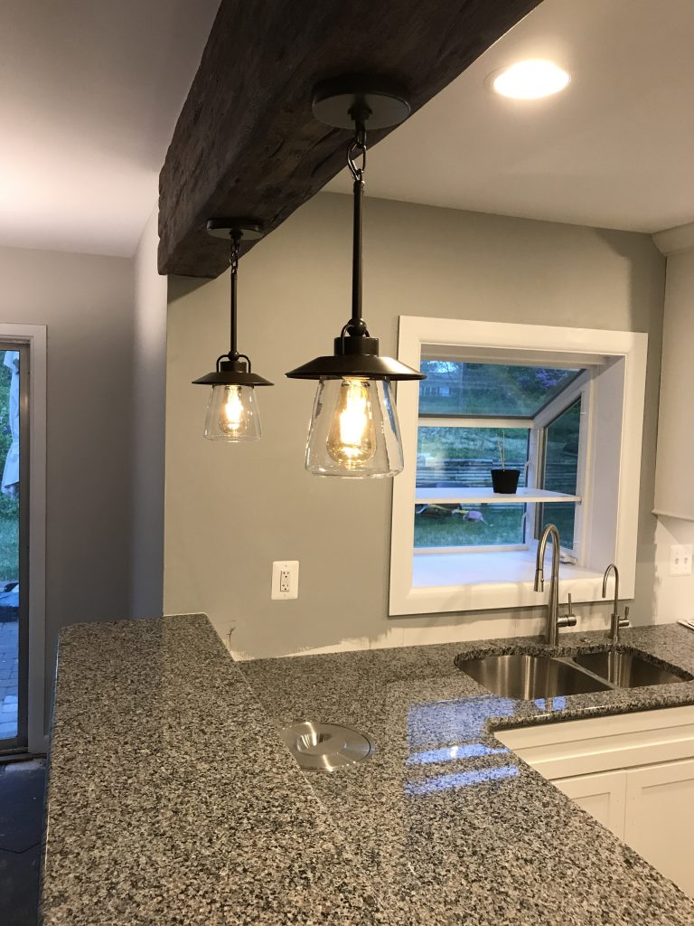 Kitchen remodel idea that's simple yet beautiful - a single beam with hanging lights over a breakfast bar.