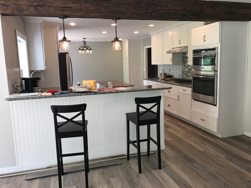 Gorgeous kitchen remodel including a single beam separating the kitchen from the living room.