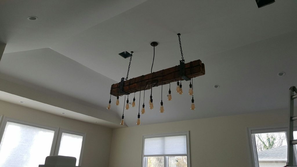 Hanging bulb light installation on a living room's gabled ceiling