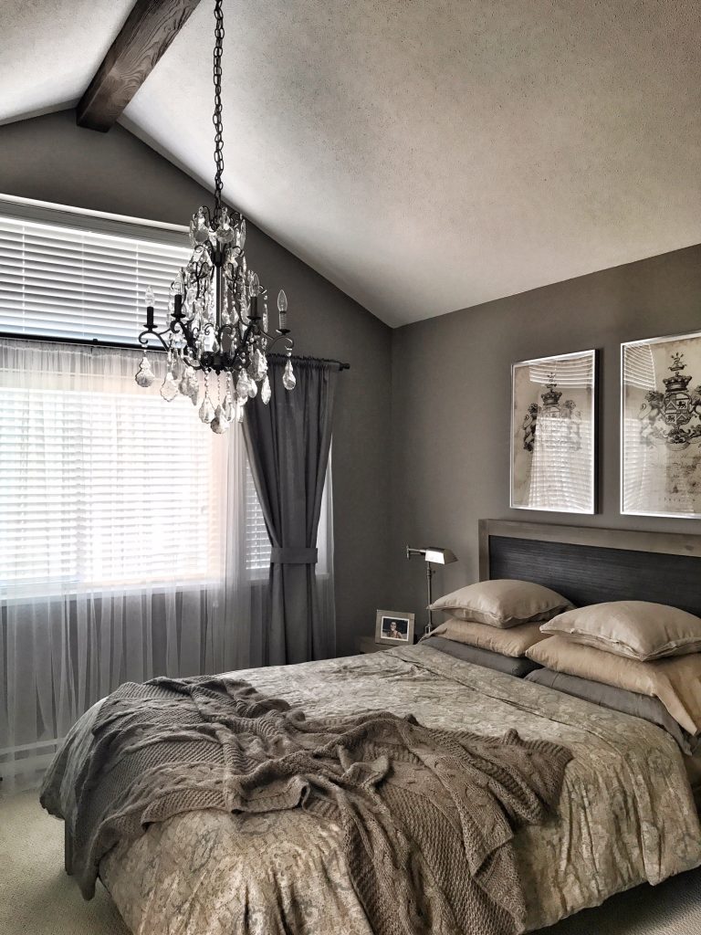 Remodeled bedroom with a beautiful chandelier installed through a Beachwood style faux beam.