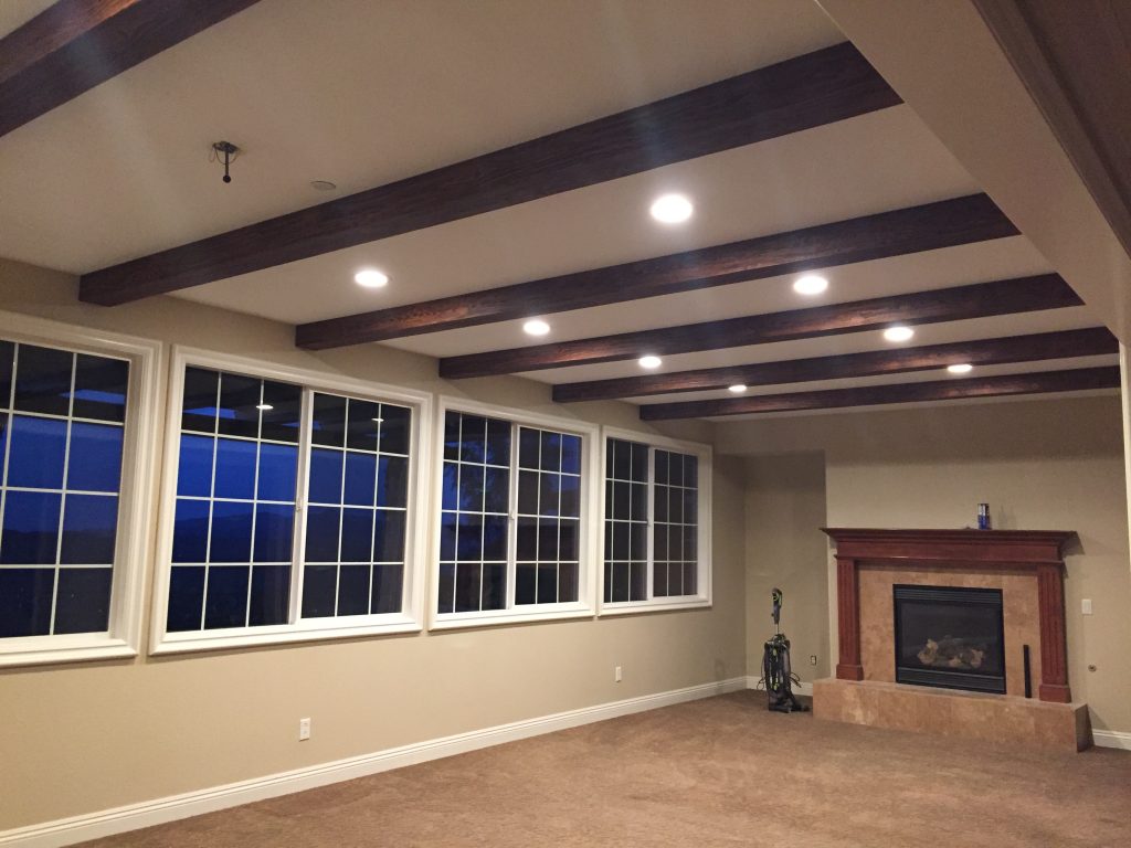 Driftwood style living room beams newly installed on a recessed ceiling.