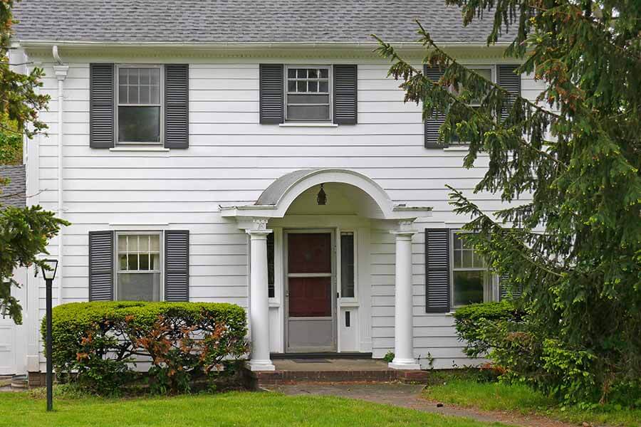 A traditional home with white aluminum exterior siding