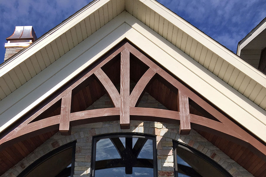 A gabled truss adorns a large window, drawing attention the home's unique exterior design.