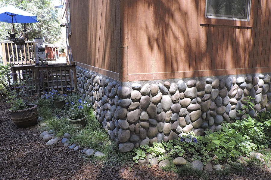 River Rock faux paneling added to the bottom edge of a house infuses a rustic feel to its exterior home design.