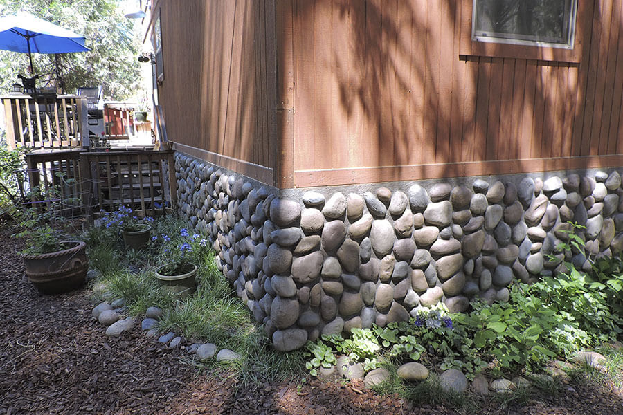 River Rock faux paneling added to the bottom edge of a house infuses a rustic feel to its exterior home design.