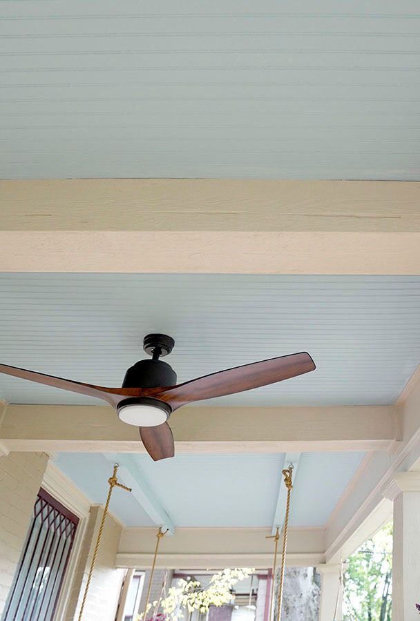 White faux wood beams on a blue porch ceiling add dimension to the home's exterior design.