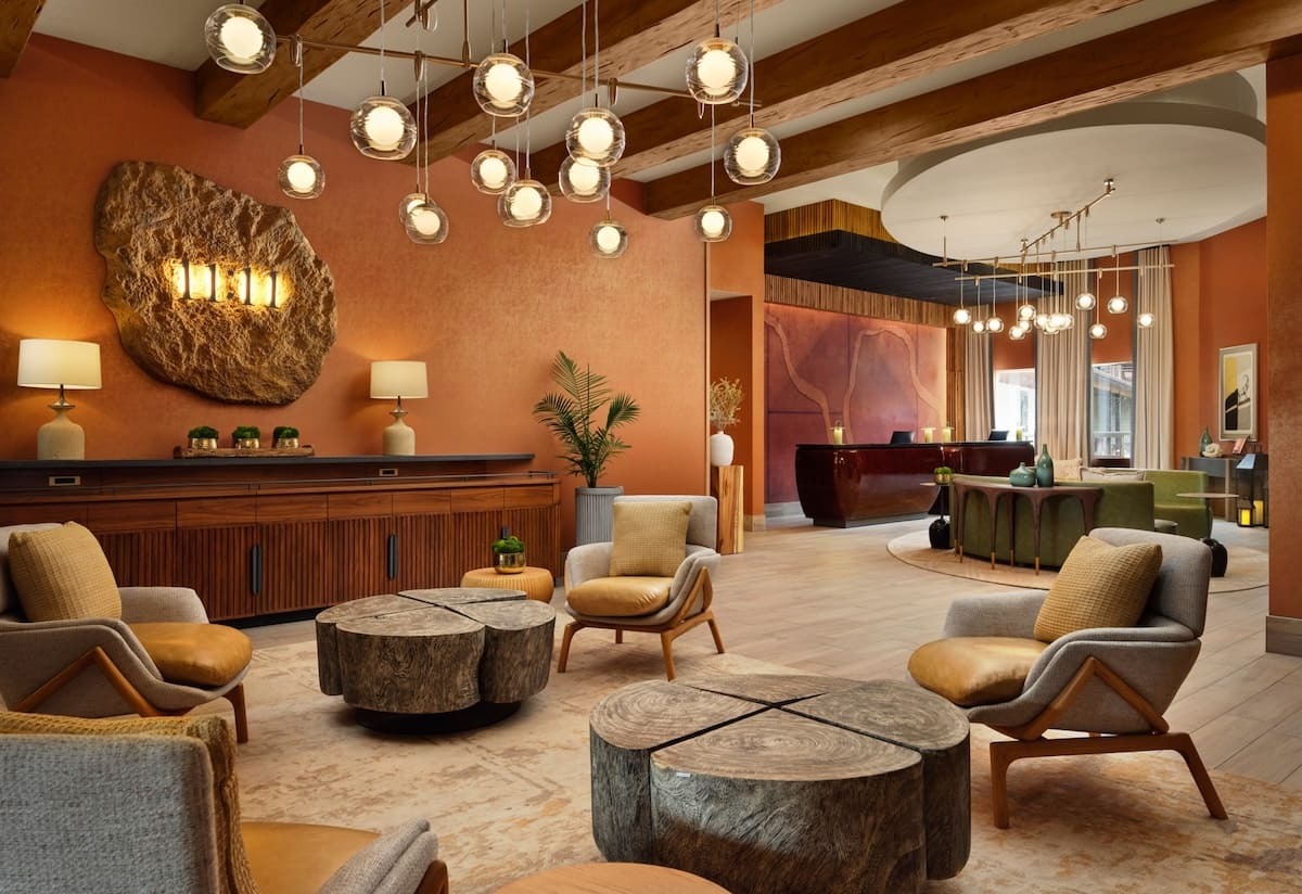Caramel hand hewn faux wood beams adding warm residential charm to hotel lobby