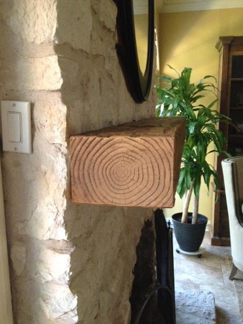 Rough Hewn faux mantel installed on a rustic stone fireplace.