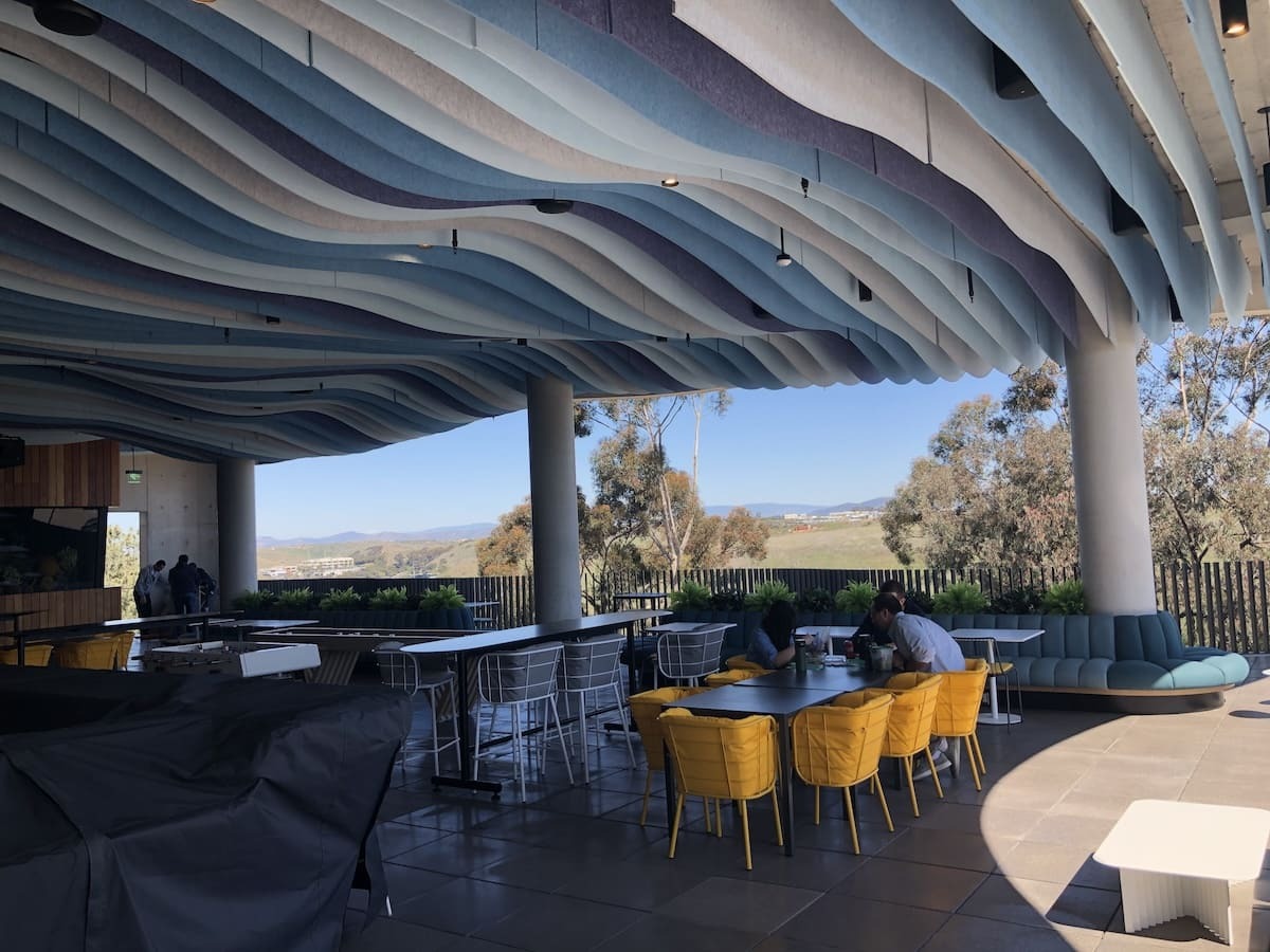 wavy cut light beige, sky blue, ocean blue, and midnight navy FSorb panels for covered outdoor area ceiling