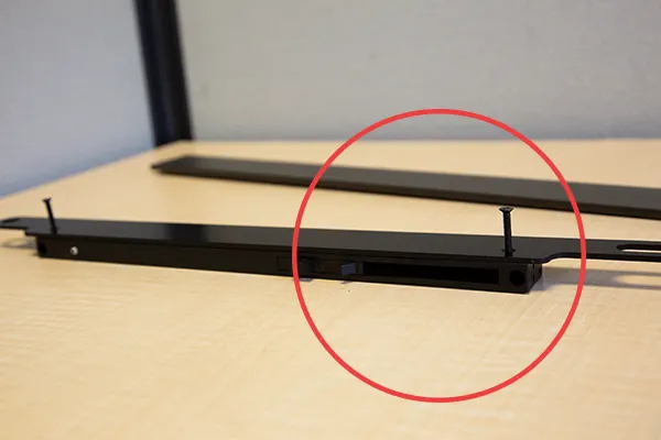The side of the Soft Stop with the triangular-shaped leg, close to the long oval slot on the bracket The side of the Soft Stop with the triangular-shaped leg, close to the long oval slot on the bracket
