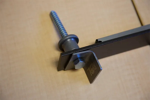 A hex lag bolt, an attached soft stop and bracket, a barn door flat track, and a standoff base,   all attached together.