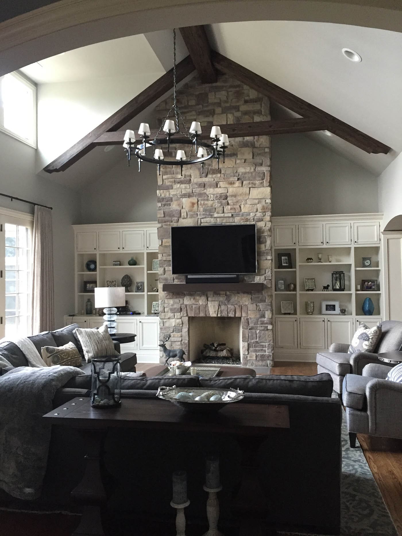 Faux wood ceiling trusses highlight the TV in a media room.